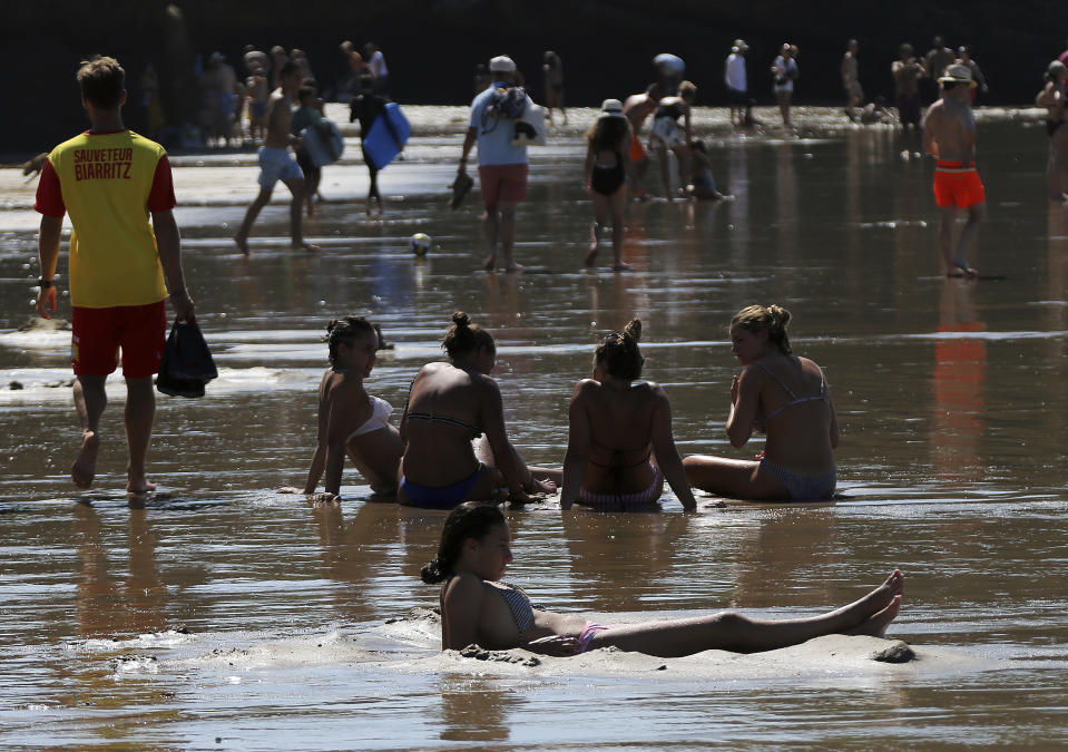 People enjoy the sea at Biarritz beach, southwestern France, southwestern France, Friday, Aug.3, 2018. The hot weather is expected to last for several days across the country. (AP Photo/Bob Edme)