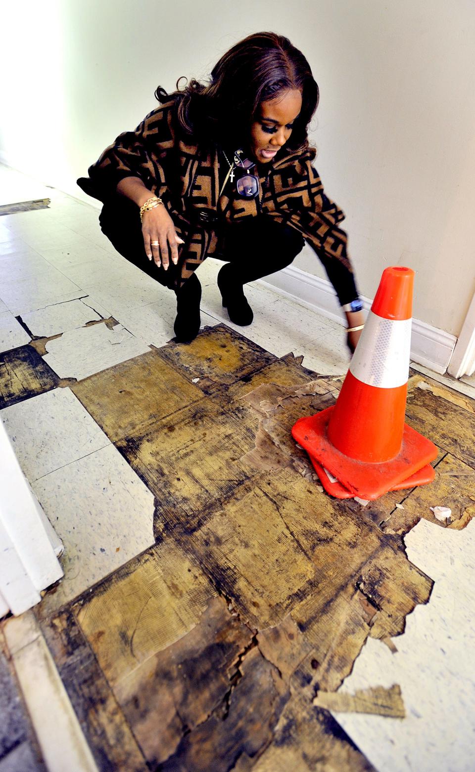 Karen Rowland, the former executive director of the Dover Interfaith Mission for Housing, placed warning cones on weakened floor caused from a water leak.