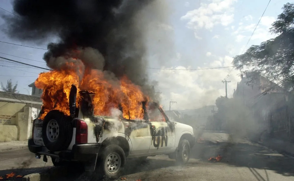 A U.N. mission car is burned by demonstrators in Haiti on Dec. 20, 2006. <a href=