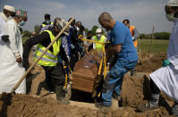 FILE - In this Friday, April 24, 2020 file photo, mourners set down the coffin of a Guinean man, who died of COVID-19 and who the family did not wish to identify by name, during a funeral at the cemetery of Evere, Belgium. After the European Union passed the death toll of half a million citizens lost to the coronavirus on Wednesday, Feb. 10, 2021, the EU Commission chief said that stalling rollout of the vaccines could be partly blamed on the bloc being over-optimistic, over-confident and plainly "too late." (AP Photo/Virginia Mayo)