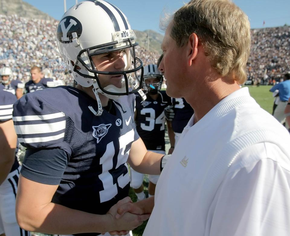 BYU’s Max Hall, left, and UCLA couch Rick Neuheisel meet at midfield after BYU handed UCLA its worst loss in 79 years, winning 59-0 at LaVell Edwards Stadium in Provo on Sept. 13, 2008. | Scott G. Winterton, Deseret News