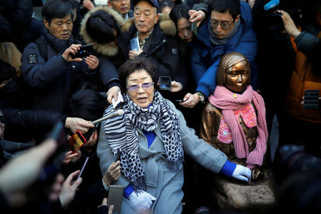 Former South Korean "comfort woman" Lee Yong-soo sits next to a statue symbolizing former South Korean "comfort woman" during the funeral of a former South Korean "comfort woman" Kim Bok-dong in Seoul, South Korea, February 1, 2019. REUTERS/Kim Hong-Ji