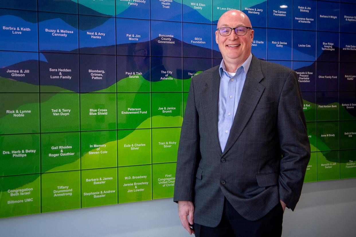 Carl Falconer, Homeward Bound's new CEO, next to the donor wall at Compass Point, December 7, 2023.