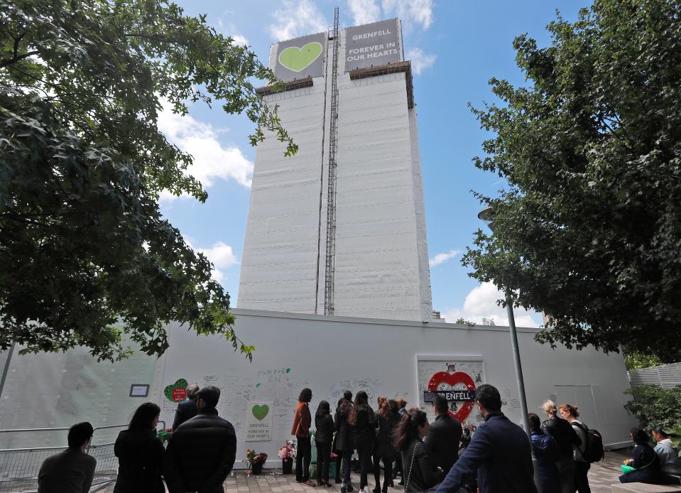 People pay their respects at the Grenfell tower to mark the two-year anniversary of the Grenfell Tower block fire, in London, Friday, June 14, 2019 (Copyright 2019 The Associated Press. All rights reserved)