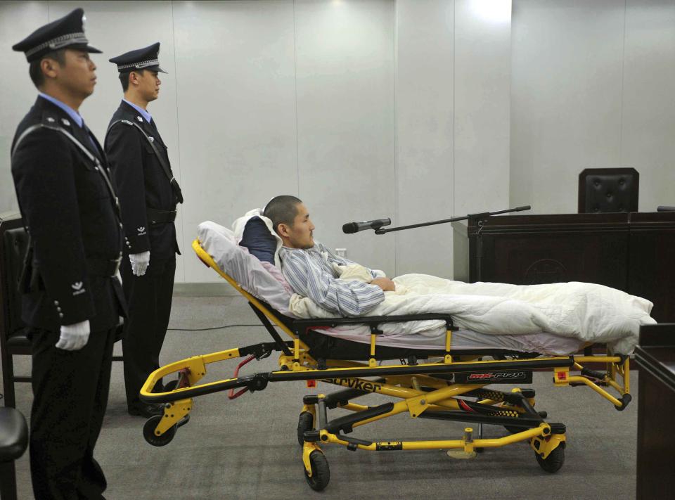 In this photo released by China's Xinhua News Agency, Ji Zhongxing, a partly paralyzed man who exploded a bomb inside Beijing's airport in July, attends his trial at the Beijing Chaoyang District People's Court in Beijing, Tuesday, Oct. 15, 2013. Ji, who exploded the bomb in hopes of winning redress over an alleged beating by public officials, was given a six-year prison sentence Tuesday. (AP Photo/Xinhua, Gong Lei) NO SALES