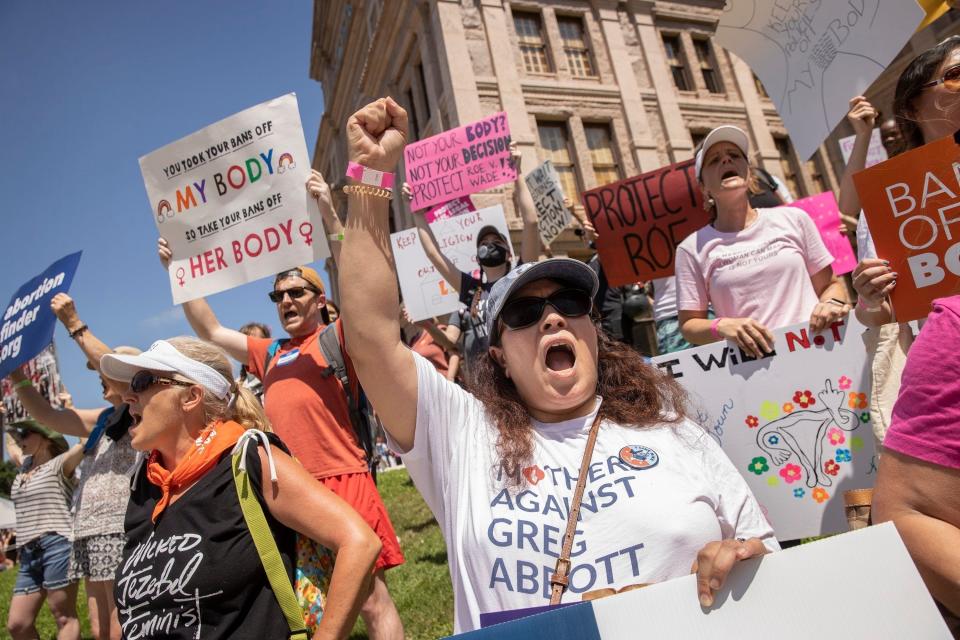 In a Mothers Against Greg Abbott shirt, Nancy Thompson, the group's founder, rallies for abortion rights at the Capitol in May 2022. Texas has banned the procedure in almost all cases, and now some cities and counties are voting to deter people from traveling through them for an out-of-state abortion.