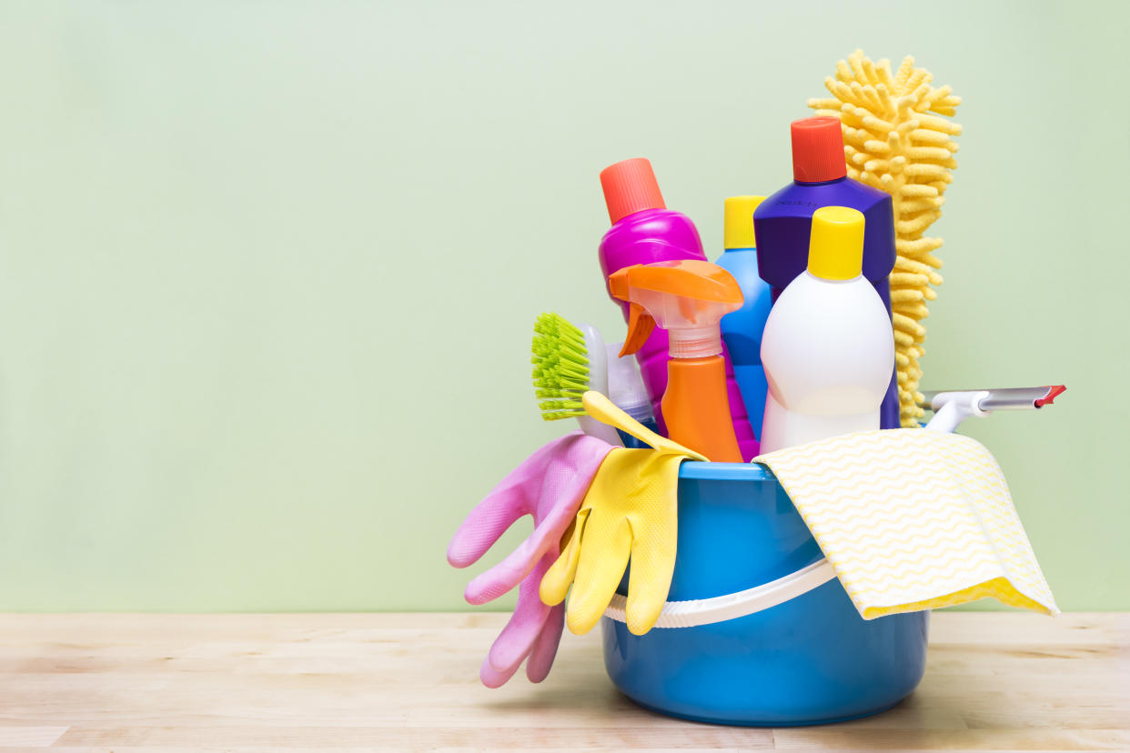 House cleaning product on wood table with green background