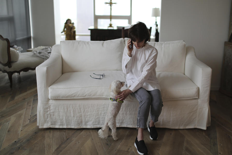 FILE - In this April 13, 2019, file photo, Laura Pontikes talks on the phone in her apartment in Houston. The Texas construction company executive and mother of three had been seeking God when she began spiritual counseling with Monsignor Frank Rossi. A Texas grand jury has declined to indict the onetime deputy to Cardinal Daniel DiNardo on charges he sexually assaulted Laura Pontikes, a married woman, in a case that raised questions about consent in the #MeToo era. The Harris County District Attorney's Office had presented the case against Monsignor Frank Rossi on Monday, more than a year after Pontikes filed a criminal complaint with Houston police. (AP Photo/Wong Maye-E, File)