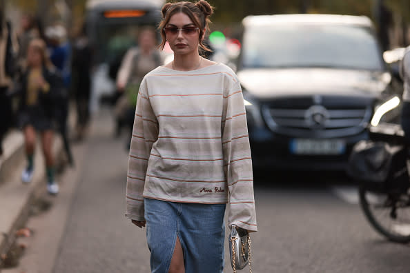 A fashion week guest seen wearing an acne studios long shirt, a gucci bag and a long jeans skirt, outside Acne Studios during Paris Fashion Week on September 28, 2022 in Paris, France.