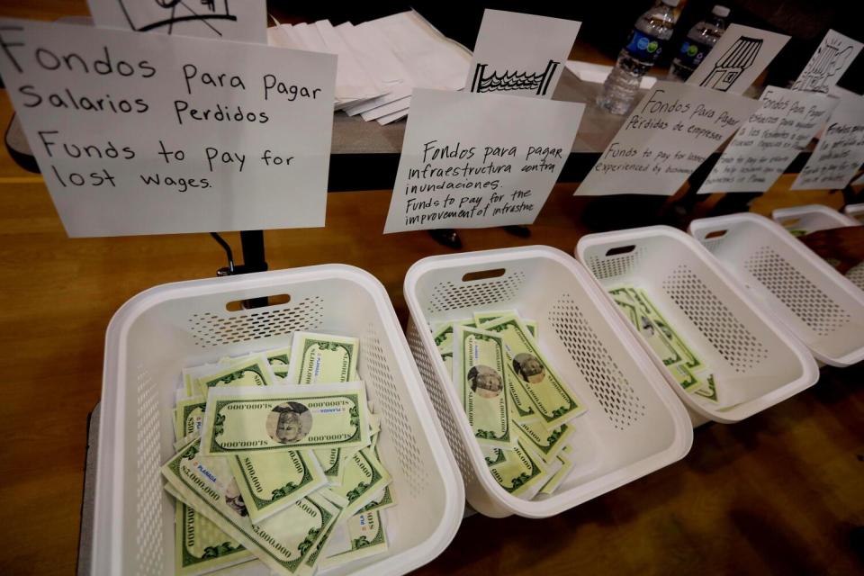 A close-up of fake money in white plastic bins