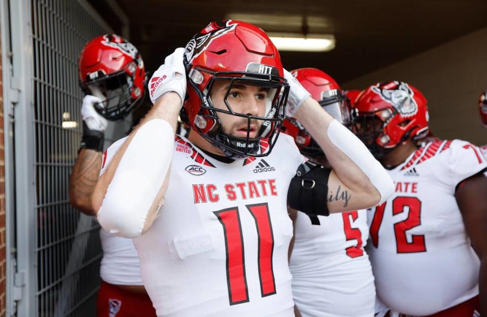 N.C. State linebacker Payton Wilson (11) adjusts his helmet before heading out onto the field to warmup before N.C. State’s game against UNC at Kenan Stadium in Chapel Hill, N.C., Friday, Nov. 25, 2022.