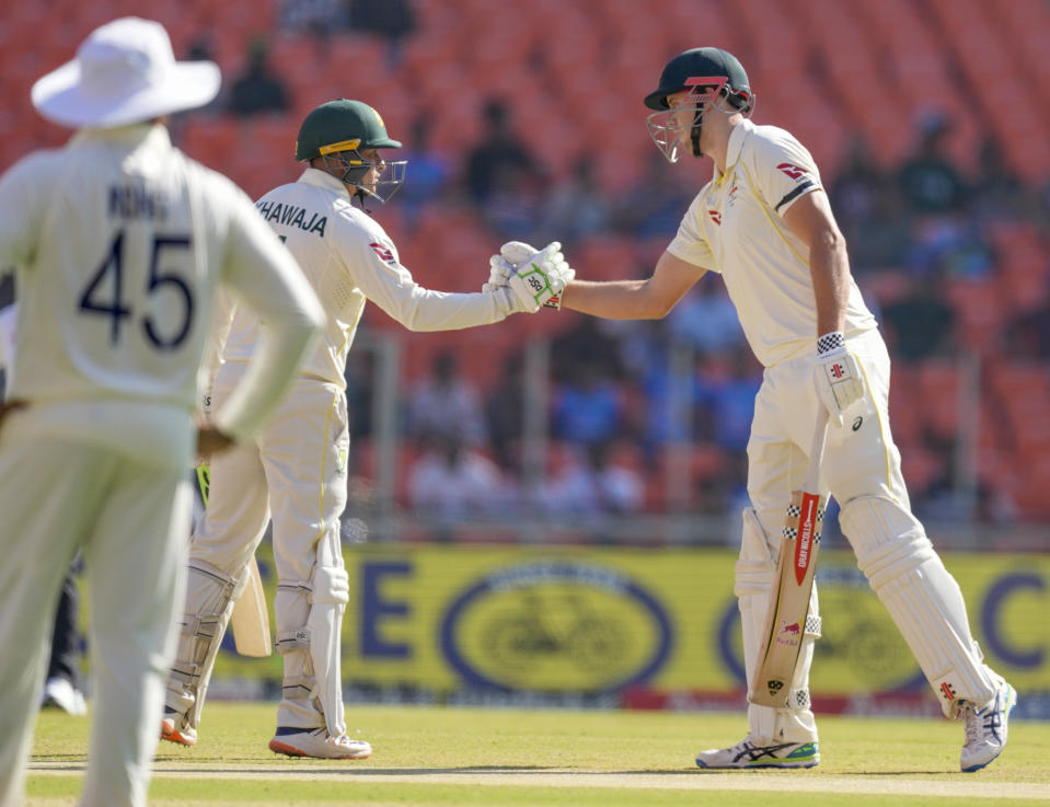 Australia's Usman Khawaja, center, greets teammate Cameron Green, right, after he scored half century during the second day of the fourth cricket test match between India and Australia in Ahmedabad, India, Friday, March 10, 2023. (AP Photo/Ajit Solanki)