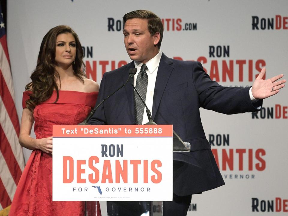 Florida Republican gubernatorial candidate Ron DeSantis, right, speaks to supporters with his wife, Casey, at an election party after winning the Republican primary in 2018 (AP)