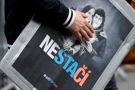 A man attends a protest rally in reaction to the murder of Slovak investigative reporter Jan Kuciak and his fiancee Martina Kusnirova, in Bratislava, Slovakia April 5, 2018. The placard shows portraits of Jan Kuciak and Martina Kusnirova and reads "Not enough". REUTERS/Radovan Stoklasa/Files