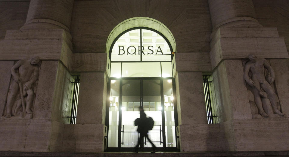 FILE - In this November 21, 2011 file photo, a man walks past the stock exchange building in Milan, Italy. Italy's market watchdog on Monday, July 23, 2012 imposed a week-long ban on the short-selling of financial stocks as the Milan index plunged amid fears that if Spain needs a bailout, Italy could be next. The main stock index, the FTSE-MIB, closed 2.8 percent lower after being down by more than 5 percent in the morning. (AP Photo/Luca Bruno, file)