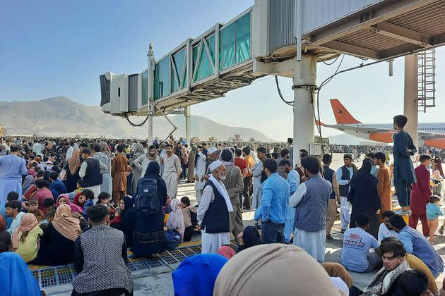 Afghans crowd the tarmac of the Kabul airport on Monday, attempting to flee the country as the Taliban takes control of Afghanistan. (Photo: - via Getty Images)