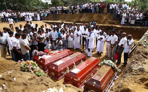 People attend burial ritual of the victims of multiple terror attacks during a funeral ceremony in Negomboo - Credit: Chamila Karunarathne/Anadolu Agency/Getty Images