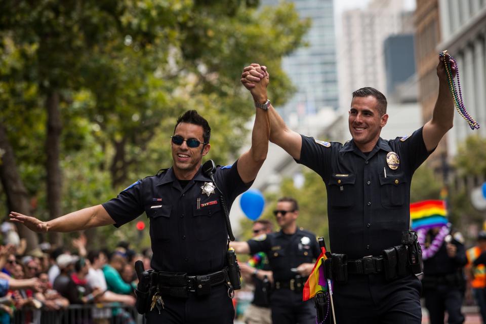 Sacramento Police Officer Jeff Kuhlmann, left, marches with his boyfriend, Los Angeles Police Officer David Ayala, right, in the San Francisco Gay Pride Parade, June 28, 2015 in San Francisco, California.