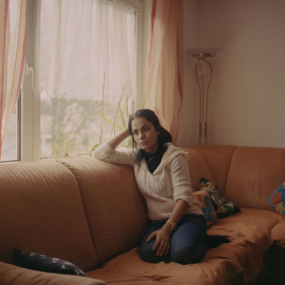 <strong>Hanan</strong> on the sofa in her living room in Germany. "<a href="https://time.com/5878967/yazidi-woman-germany-program/" rel="nofollow noopener" target="_blank" data-ylk="slk:A Radical German Program Promised a Fresh Start to Yazidi Survivors of ISIS Captivity. But Some Women Are Still Longing for Help;elm:context_link;itc:0;sec:content-canvas" class="link ">A Radical German Program Promised a Fresh Start to Yazidi Survivors of ISIS Captivity. But Some Women Are Still Longing for Help</a>," Aug. 24.<span class="copyright">Tori Ferenc—INSTITUTE for TIME</span>