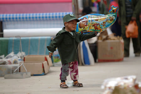 A boy dressed as a United Wa State Army (UWSA) soldier, plays in a market at Mongmao, Wa territory in northeast Myanmar October 1, 2016. REUTERS/Soe Zeya Tun