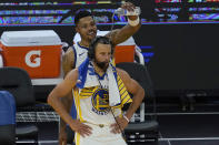 Golden State Warriors forward Kent Bazemore, top, pours water on the head of guard Stephen Curry after an NBA basketball game against the Memphis Grizzlies in San Francisco, Sunday, May 16, 2021. (AP Photo/Jeff Chiu)