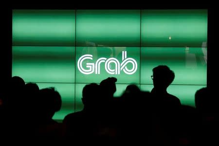 FILE PHOTO: People wait for the start of Grab's fifth anniversary news conference in Singapore June 6, 2017. REUTERS/Edgar Su/File Photo