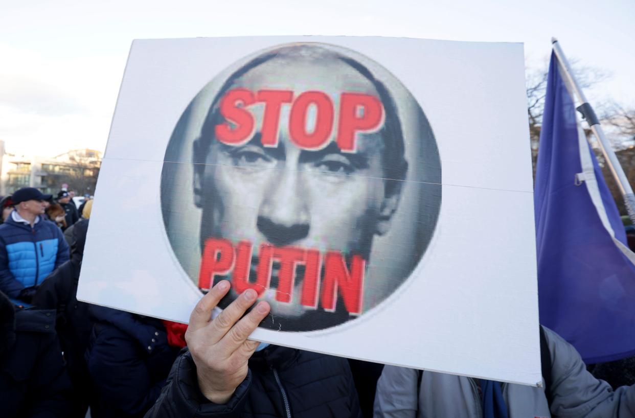 Protesters hold posters and Ukrainian flags as they protest against Russia's military intervention in Ukraine in front of the Russia Embassy in Sofia, Bulgaria, on Thursday, Feb. 24, 2022.