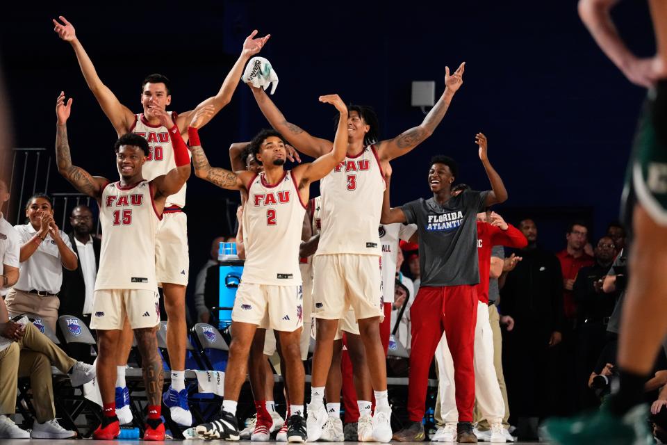 The Owls celebrate cracking the 100-point mark during Tuesday night's win over Eastern Michigan.