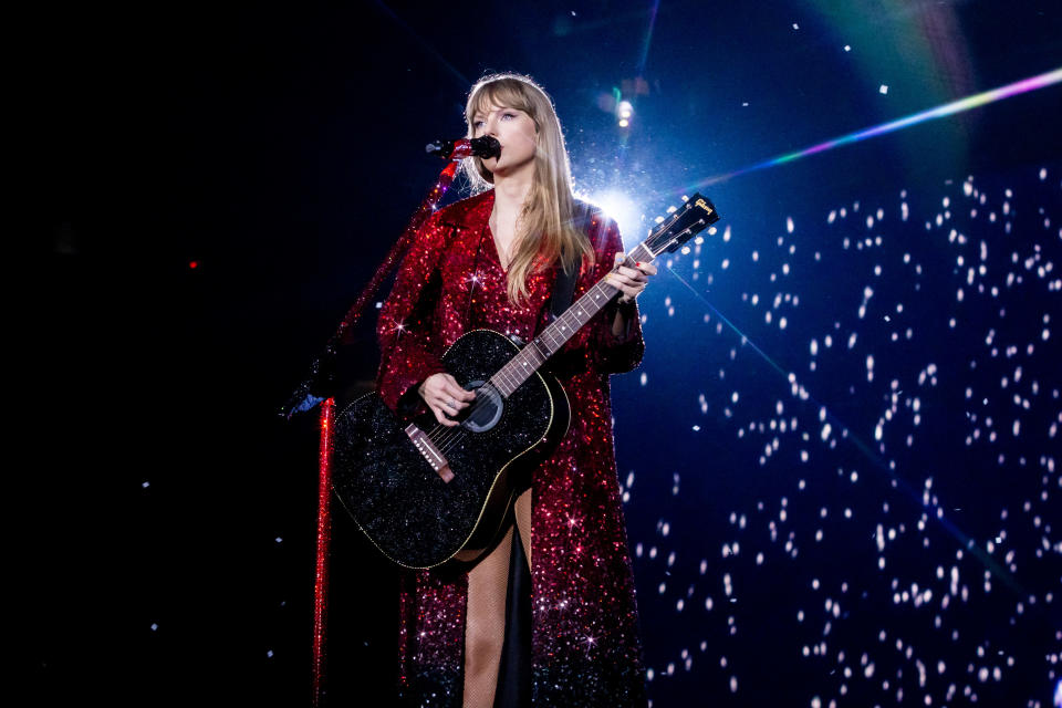 Taylor Swift performing in a sparkling red dress during the "Red" setlist of The Eras Tour