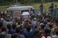 Kashmiri men carry the coffin of Waseem Ahmed, a policeman who was killed in a shootout, out of an ambulance on the outskirts of Srinagar, Indian controlled Kashmir, Sunday, June 13, 2021. Two civilians and two police officials were killed in an armed clash in Indian-controlled Kashmir on Saturday, police said, triggering anti-India protests who accused the police of targeting the civilians. (AP Photo/ Dar Yasin)