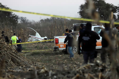 Police and rescue personnel stand at the scene where the helicopter transporting Martha Erika Alonso, governor of the state of Puebla, and his husband Senator Rafel Moreno Valle crashed, in Coronango, Puebla Mexico, December 24, 2018. REUTERS/Imelda Medina
