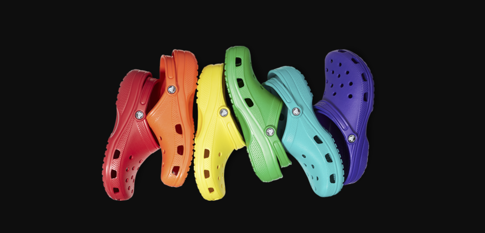 Six Crocs shoes in the colors of the rainbow.