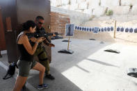 <p>An Israeli instructor guides a tourist as she fires a rifle during a two hour “boot camp” experience, at “Caliber 3 Israeli Counter Terror and Security Academy” in the Gush Etzion settlement bloc south of Jerusalem in the occupied West Bank July 13, 2017. (Photo: Nir Elias/Reuters) </p>