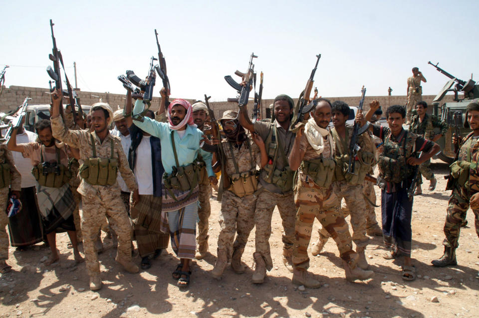In this photo provided by Yemen's Defense Ministry, Yemen's army soldiers hold up their weapons at an area seized from al-Qaida in the southeastern province of Shabwa, Yemen, Thursday, May 8, 2014. Yemeni armed forces on Thursday swept al-Qaida fighters out of a district in the country's south, one of the main goals of the major offensive waged by the military the past two weeks, the Defense Ministry said, amid fears of retaliatory attacks which officials say prompted the closure of the US embassy in the capital as a precaution. (AP Photo/Yemen's Defense Ministry)