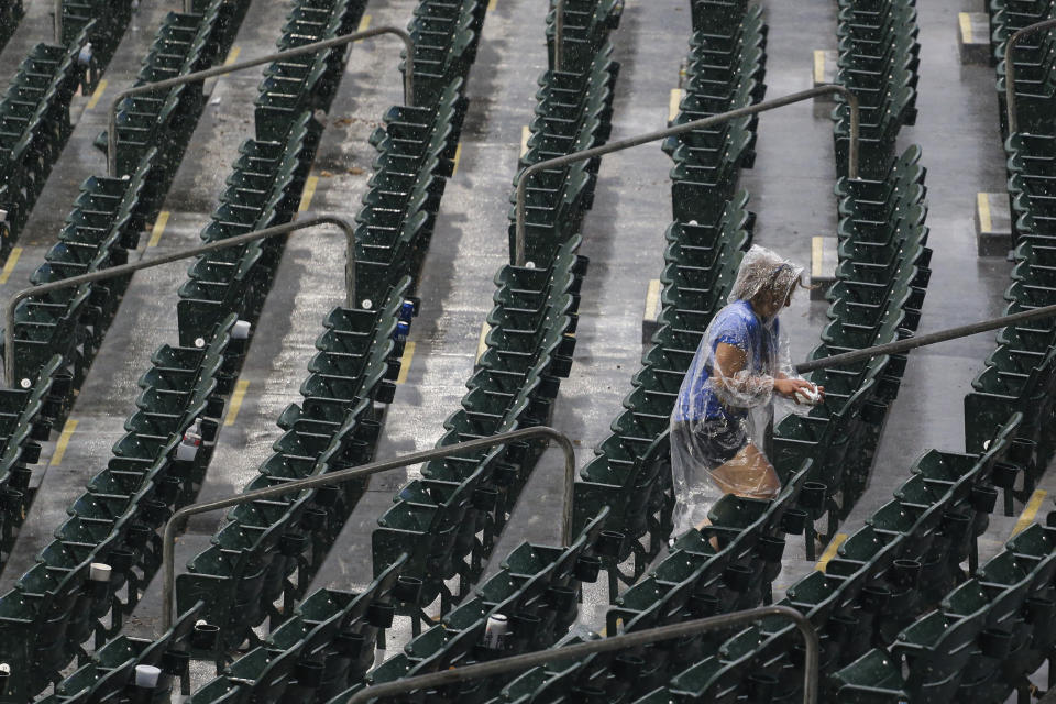 A fan tries to escape the rain after the baseball game between the Toronto Blue Jays and Boston Red Sox was postponed, Tuesday, July 20, 2021, in Buffalo, N.Y. (AP Photo/Joshua Bessex)