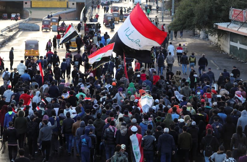 Mourners carry a mock coffin for an Iraqi demonstrator, who was killed during ongoing anti-government protests, at a symbolic funeral in Baghdad