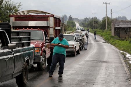 A driver checks his phone as members of the Supreme Indigenous Council block the entry to their community to avoid the installation of polling stations for Mexico's general election in the indigenous Purepecha town of Zirahuen, in Michoacan state, Mexico June 28, 2018. Picture taken June 28, 2018. REUTERS/Alan Ortega