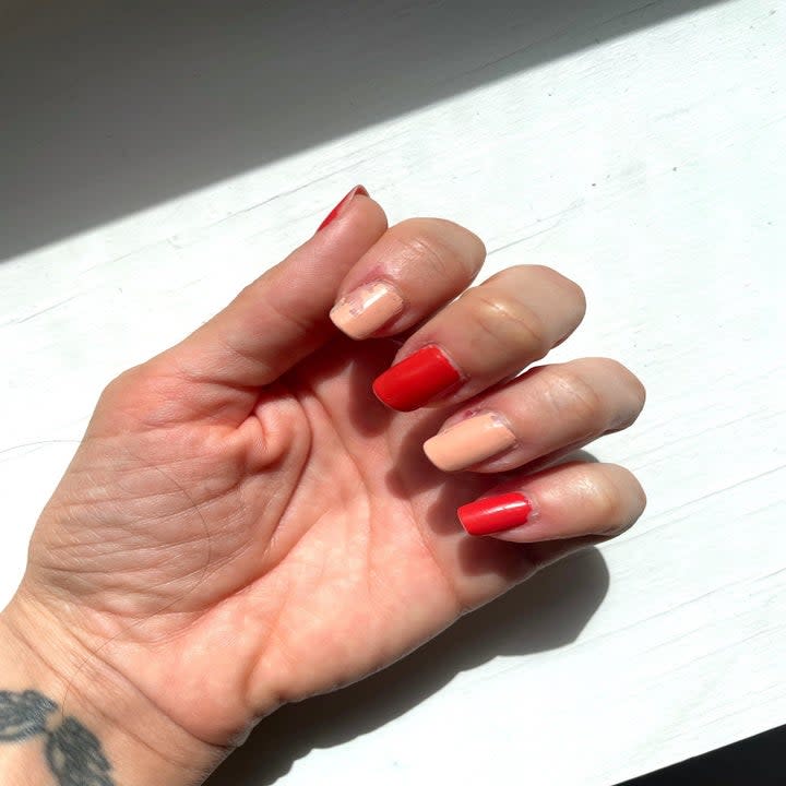 close up of hand with pink and red polish