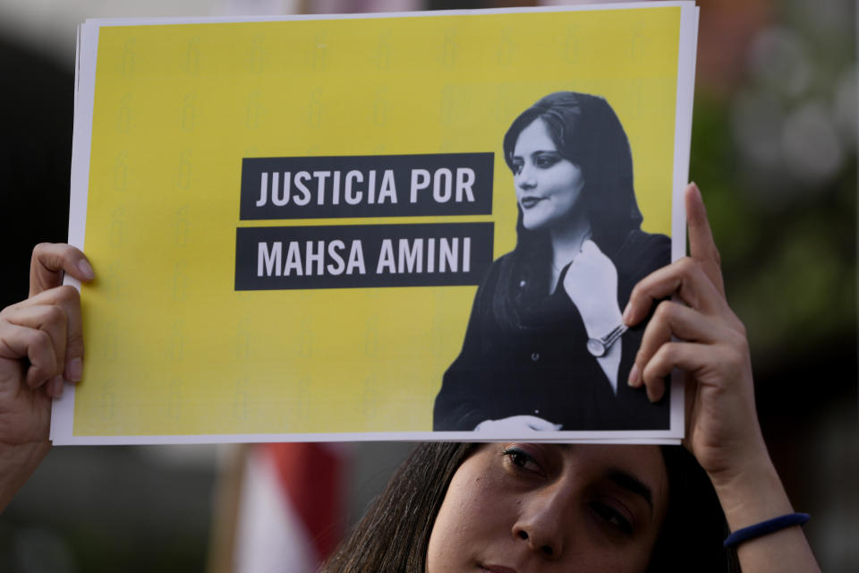 FILE - A woman holds a sign that reads in Spanish "Justice for Mahsa Amini" as she protests against the death of Amini, an Iranian woman who died while in police custody in Iran, in front of the Iranian embassy in Buenos Aires, Argentina, Tuesday, Sept. 27, 2022. As anti-government protests roil cities and towns in Iran for a fourth week, sparked by the death of Amini, tens of thousands of Iranians living abroad have marched on the streets of Europe, North America and beyond in support of what many believe to be a watershed moment for their home country. (AP Photo/Natacha Pisarenko, File)