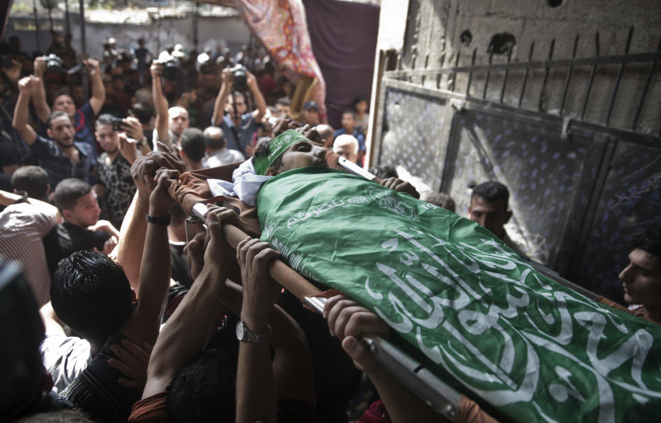 Mourners carry the body of 12-year-old Palestinian boy, Fares Sersawi, who was killed by Israeli troops on Friday's protest at the Gaza Strip's border with Israel, out of the family home during his funeral in Gaza City, Saturday, Oct. 6, 2018. (AP Photo/Khalil Hamra)