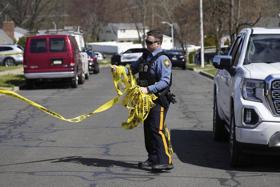 A police officer removes crime scene tape after a shooting was reported in Levittown, Pa., Saturday, March 16, 2024. Authorities have issued a shelter-in-place order following the shooting of multiple people in a suburban Philadelphia township. (AP Photo/Matt Rourke)