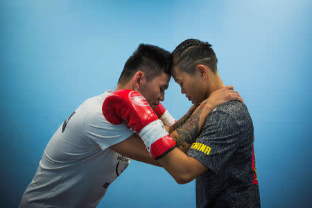 Huang Wensi and her assistant coach stand as the coach says a few motivational words before a match in Taipei, Taiwan, September 26, 2018. REUTERS/Yue Wu