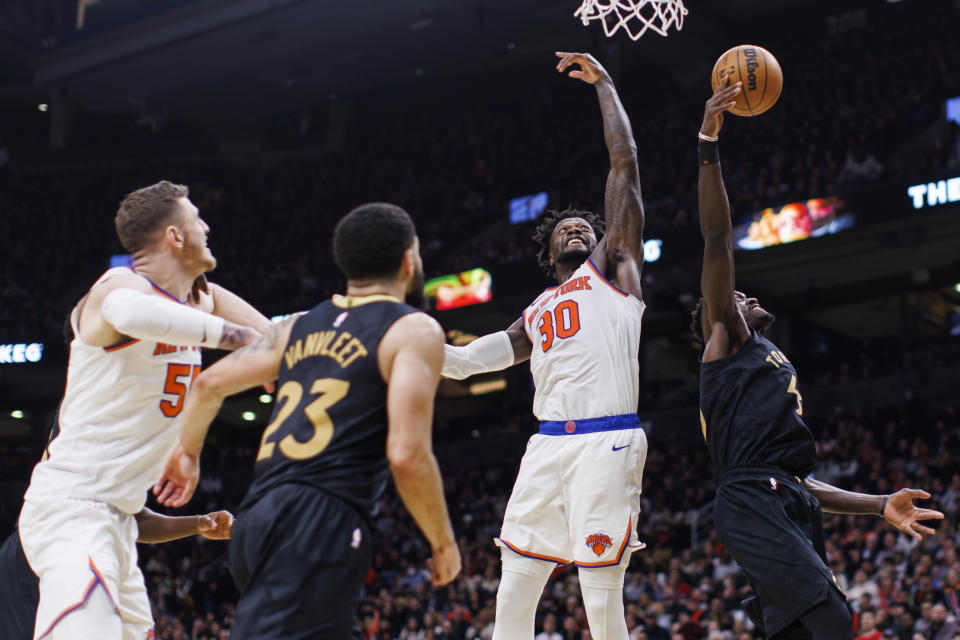 New York Knicks forward Julius Randle (30) and Toronto Raptors forward Pascal Siakam (43) reach for a rebound during the second half of an NBA basketball game Friday, Jan. 6, 2023, in Toronto. (Cole Burston/The Canadian Press via AP)