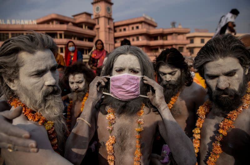 FILE PHOTO: A Naga Sadhu, or Hindu holy man wears a mask before the procession for taking a dip in the Ganges river during Shahi Snan at "Kumbh Mela", or the Pitcher Festival, amidst the spread of the coronavirus disease (COVID-19), in Haridwar