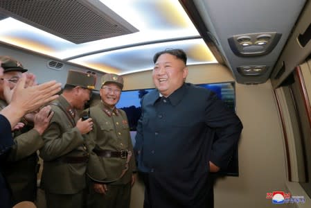 FILE PHOTO: North Korean leader Kim Jong Un smiles as he guides missile testing at an unidentified location in North Korea