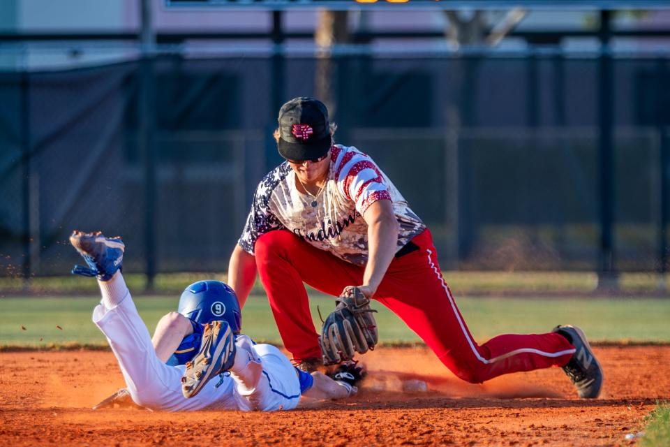 Martin County's Will Perry (9) gets his hand safely back on second base under the tag of Vero Beach's Caleb Wood (2) in a high school baseball game at Vero Beach High School on Wednesday, April 17, 2024.