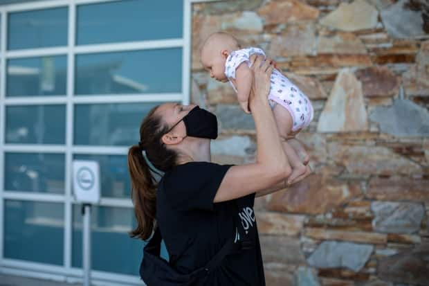 Team Canada basketball player Kim Gaucher, seen above with daughter Sophie at the Vancouver International Airport on Thursday, says she's being forced to choose between the 2020 Tokyo Olympics and breastfeeding her three-month-old daughter due to COVID-19 rules that prevent family from attending the Summer Games. (Ben Nelms/CBC - image credit)