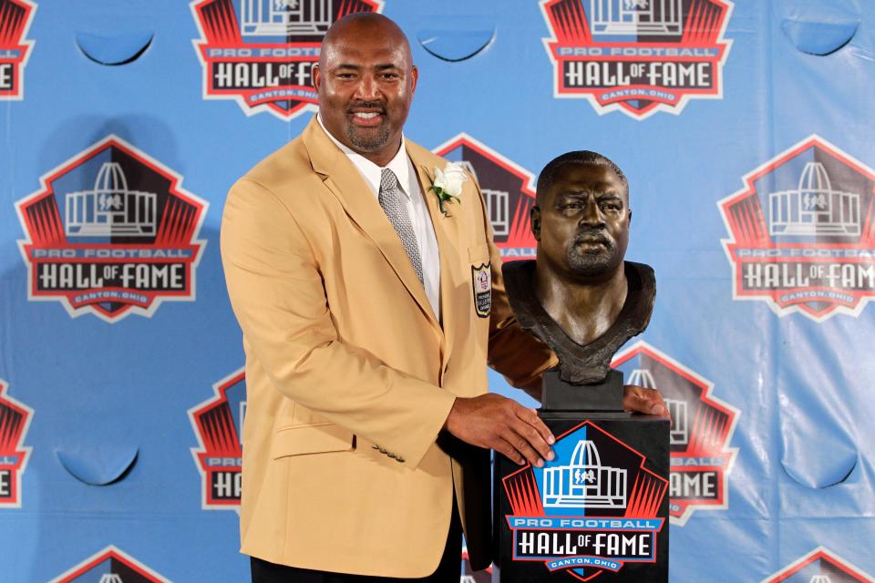 Former NFL player Dermontti Dawson poses with a bust of himself during an induction ceremony at the Pro Football Hall of Fame in August 2012.