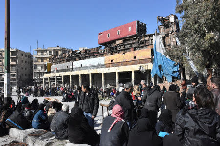 People, who were evacuated from the eastern districts of Aleppo, wait with their belongings in a government held area of Aleppo, Syria, in this handout picture provided by SANA on December 8, 2016. SANA/Handout via REUTERS