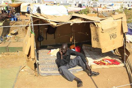 A displaced man speaks on a cellphone in his makeshift shelter at Tomping camp, where some 15,000 displaced people who fled their homes are sheltered by the United Nations, near South Sudan's capital Juba January 7, 2014. REUTERS/James Akena